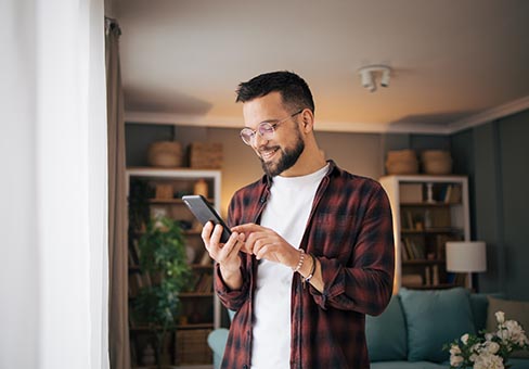 man smiling while using smartphone